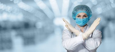 Karantina yasağı konsepti. Doktor maskesi elleriyle yasaklayıcı bir jest gösteriyor..