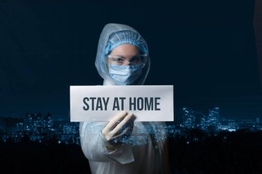 Doktor evde kal yazan bir tabela tutuyor. Karantinaya uyma kavramı.
