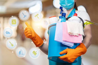 Maskeli bir temizlikçi kadın bulanık bir arka planda çalışmanın kalitesini gösterir..