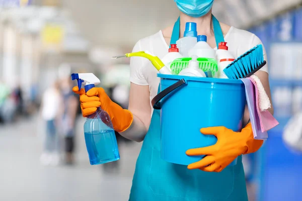 Sprzątaczka Masce Trzyma Spray Wiadro Środków Czyszczących Ręku Rozmytym Tle — Zdjęcie stockowe