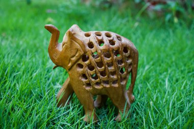 Hindistan 'daki Rajasthan' lı zanaatkarlar tarafından yeşil çimenlerin arka planında işlenmiş, kadamb ağacından yapılmış zarif bir fil. Bebek filin içi oyulmuştur..