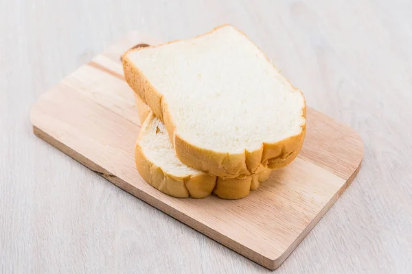 Pão fatiado a mesa de madeira — Fotografia de Stock