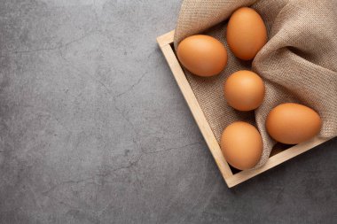 Siyah masadaki ahşap tepside tavuk yumurtası. Üst görünüm.