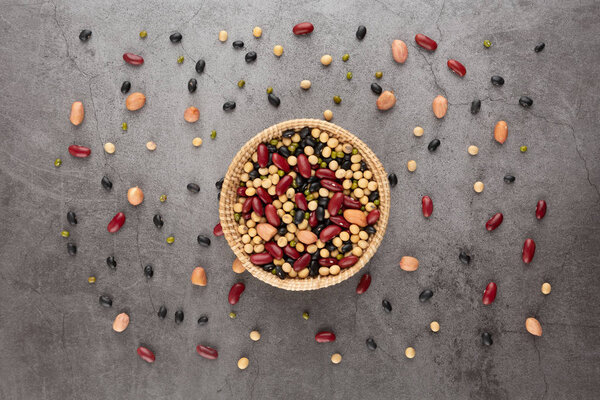 Grains or beans, red bean, black bean, green bean, soybean, peanut in the wooden basket placed on the black cement floor. High angle view.