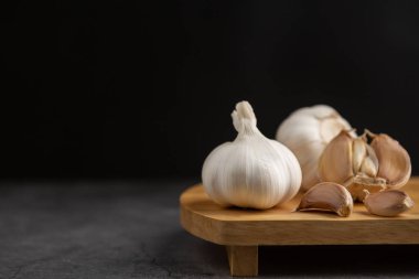 Siyah masa ve siyah arkaplanda sarımsak..