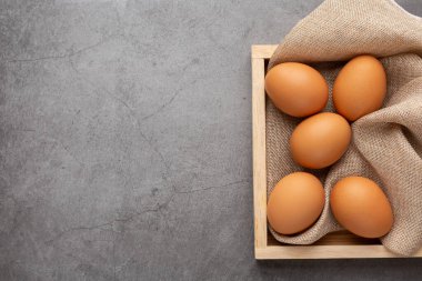 Siyah masadaki ahşap tepside tavuk yumurtası. Üst görünüm.