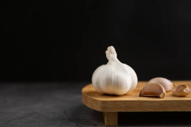 Siyah masa ve siyah arkaplanda sarımsak..