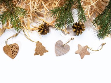 Yeni yıl. Beyaz bir arka plan tasarla. Doğal malzemelerden yapılmış şenlikli dekorasyonlar - köknar dalları, koniler, ahşap talaşlar, Noel oyuncakları.