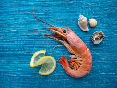 Mavi ahşap masada limonlu bir karides.