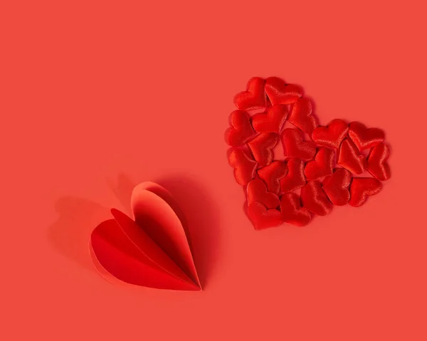 Röda ljusa hjärtan på en röd bakgrund. Alla hjärtans dag semester. Kärlekens symbol. — Stockfoto