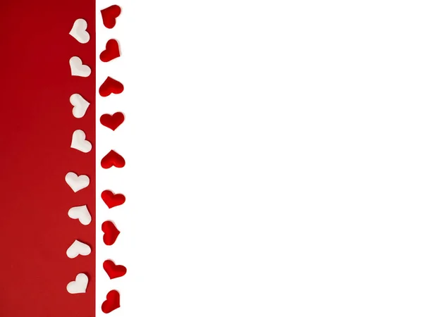 Många röda hjärtan i rad på en vit isolerad bakgrund. Vita hjärtan på en klarröd bakgrund. Omslag, vykort — Stockfoto