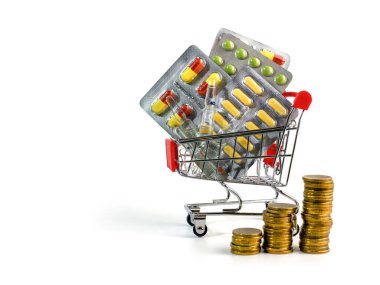İlaçlar. Eczacılık ürünleri, tabletler, kapsüller, ampuller beyaz izole bir zemin üzerinde bir alışveriş arabasında. Yanında bir yığın madeni para var. İlaç al.