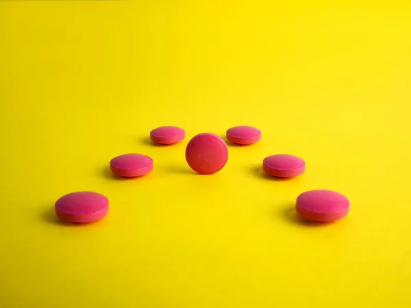 Droga. Comprimidos redondos vermelhos sobre um fundo amarelo. Medicina, produtos farmacêuticos — Fotografia de Stock