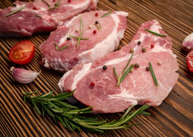 Çiğ et, tahtadan yapılmış biftek. Baharat, sarımsak, biberiye, biber, domates. Pişirmeye ve kızartmaya hazırım..