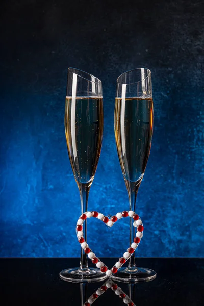 Два бокала с шампанским на поверхности черного зеркала — стоковое фото