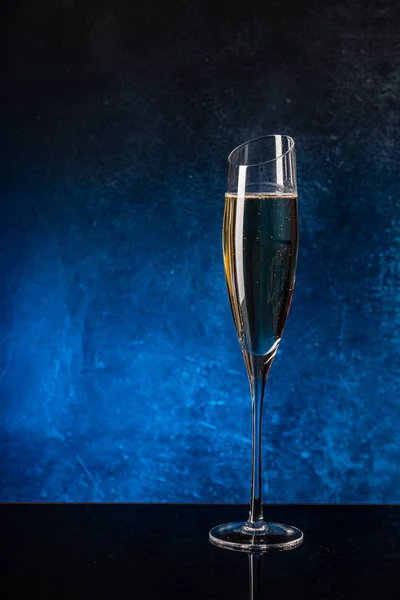 Glas mit Champagner auf schwarzer Spiegeloberfläche lizenzfreie Stockbilder