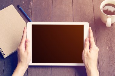 Ahşap masa kahve dükkanında çalışan tablet tutan el kadın 