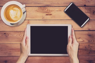 Ahşap masa kahve dükkanında çalışan tablet tutan el kadın 