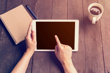 Ahşap masa kahve dükkanında çalışan tablet tutan el kadın 