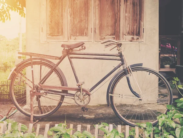 Vintage bicycle or old bicycle vintage park on old wall home. — Stock Photo, Image