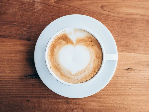 Bovenaanzicht cup en koffie op de houten tafel — Stockfoto