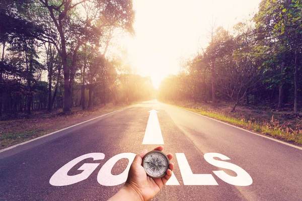 Hand holding compass on Empty asphalt road and Goals concept. — Stock Photo, Image