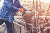 Arbeiter mischt Zementmörtel-Putz für den Bau mit vi