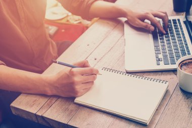 Yazma ve kafede dizüstü kullanarak genç iş adamı el 