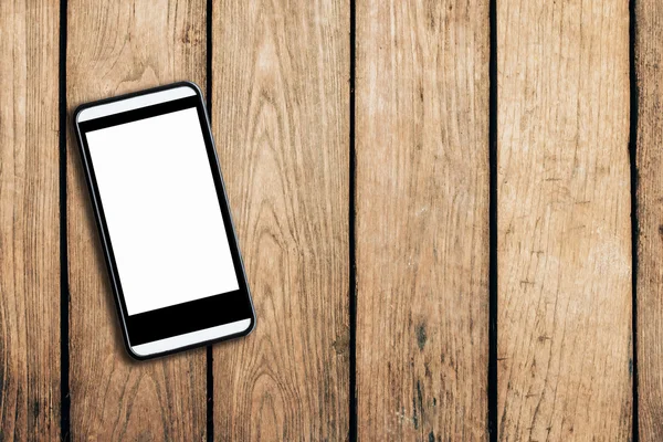 Mobilní telefon na dřevěný stůl texturu pozadí s prostorem. — Stock fotografie
