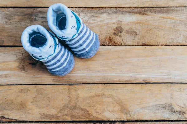 Baby shoes on wooden background with space — Stock Photo, Image