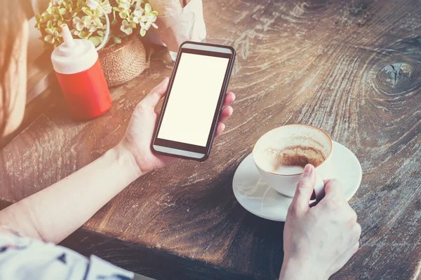 Primer plano de la mujer de la mano usando el teléfono en la cafetería con t Vintage —  Fotos de Stock