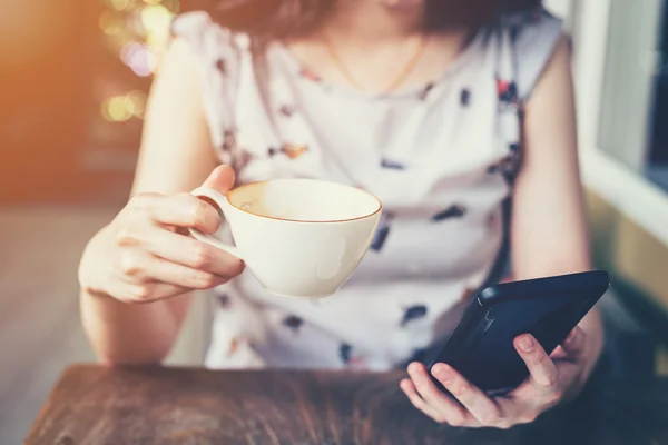 Close up van hand vrouw met behulp van de telefoon in de koffieshop met diepte van — Stockfoto