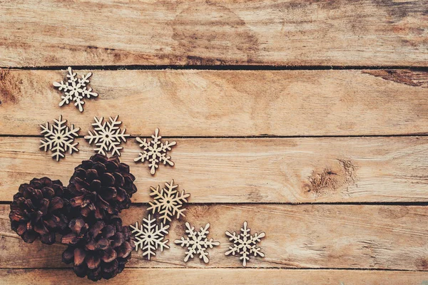 Conos de pino y copos de nieve en madera para el fondo de Navidad con —  Fotos de Stock