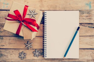 Noel için hediye kutusu, kar taneleri ve defter ahşap üzerine kahverengi n
