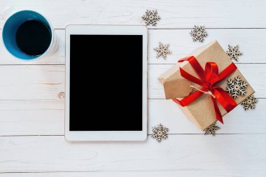 Üstten Görünüm tablet, fincan kahve ve hediye kutusu WHI üzerinde kar taneleri ile