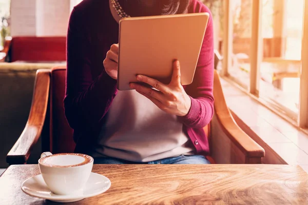 Vrouw hand met behulp van Tablet PC in koffiehuis café met vintage toned. — Stockfoto