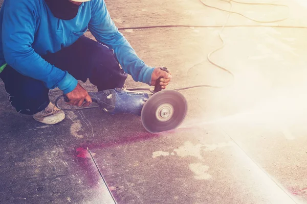 Fermer main homme coupe plancher de béton avec machine . — Photo