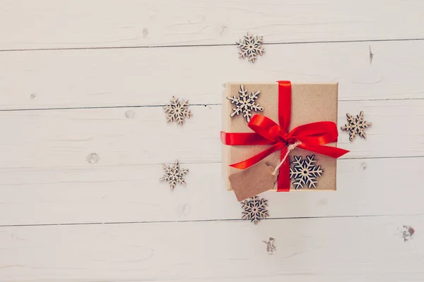 Caja de regalo marrón y copos de nieve sobre fondo de madera blanco. Vintag. — Foto de Stock