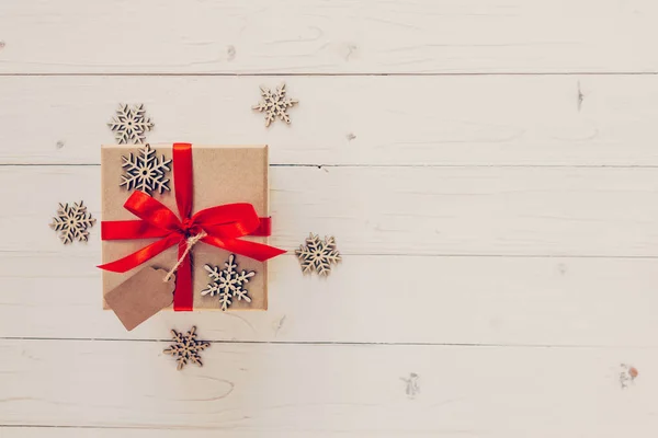 Caja de regalo marrón y copos de nieve sobre fondo de madera blanco. Vintag. — Foto de Stock