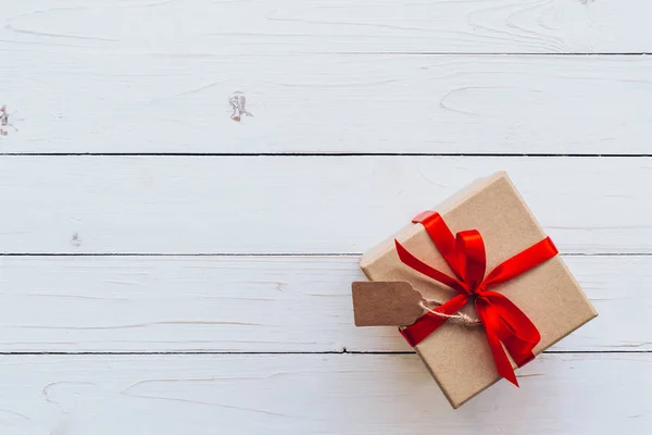 Por encima de la caja de regalo marrón con etiqueta sobre fondo de tabla de madera. Regalo b —  Fotos de Stock