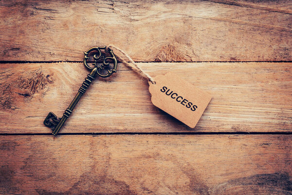Business concept - Old key vintage on wood with tag Success.