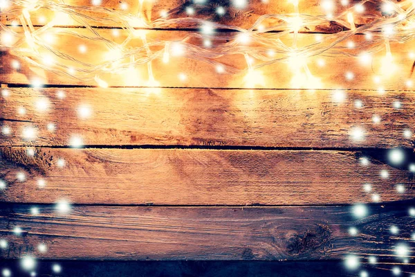 Luz de Natal e neve no fundo de madeira com espaço — Fotografia de Stock