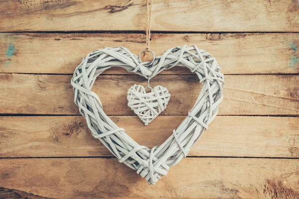 Two wooden rustic decorative hearts hanging on vintage wooden ba — Stock Photo, Image