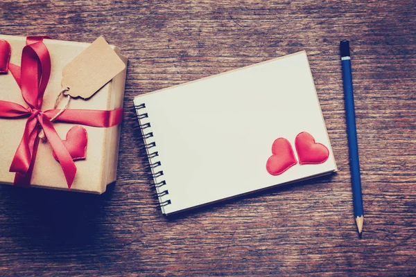 Vista superior (arriba) caja de regalo y cinta roja y corazón rojo con nota — Foto de Stock