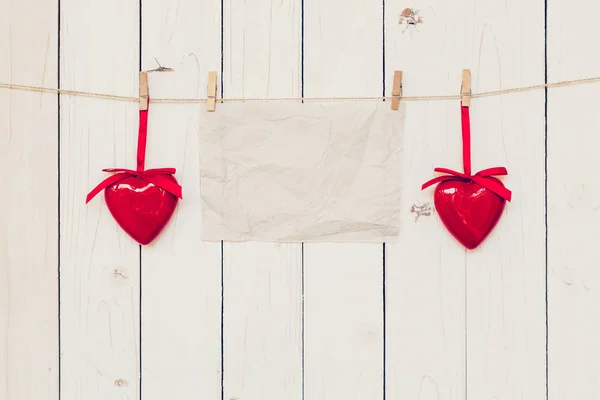 Blank old paper and red heart hanging on wood board background w — Stock Photo, Image