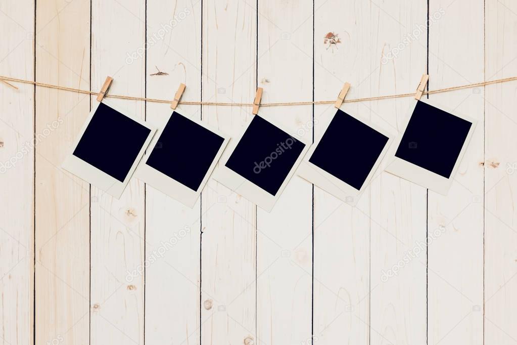 Five (5)blank photo frame hanging on white wood background with 