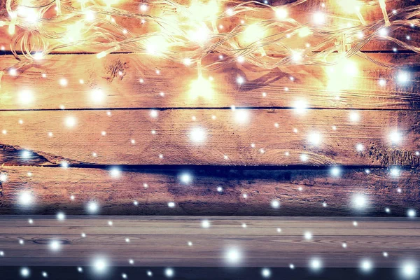 Luz de Natal, neve no fundo de madeira e mesa de madeira com — Fotografia de Stock