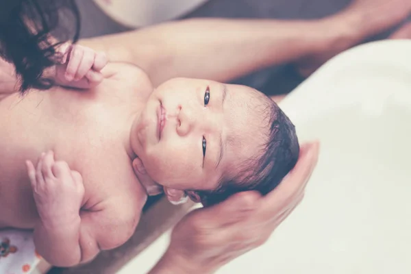 Nyfödd baby flicka med ett bad med mammas hjälp — Stockfoto