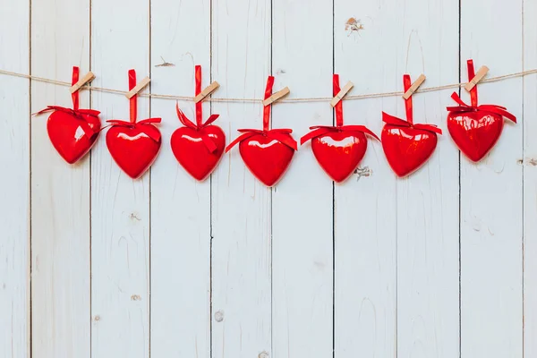 Red heart hanging at clothesline on wood white background with s — Stock Photo, Image