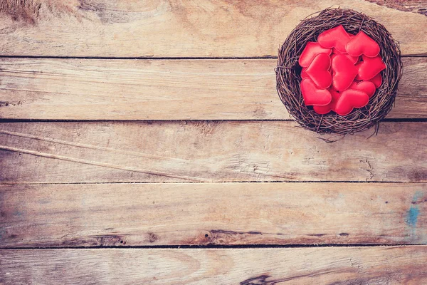 Corazón rojo en el nido sobre fondo de madera con espacio — Foto de Stock